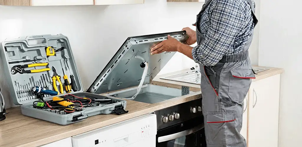 Handyman repairing a cooktop and checking wiring connections in Eugene, OR