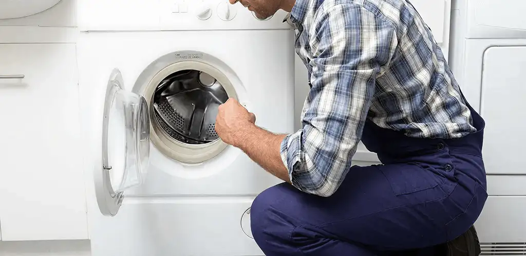 Handyman inspecting a dryer drum and internal parts for repair in Eugene, OR