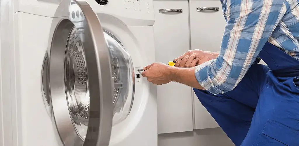 Handyman repairing a clothes dryer and checking electrical connections in Eugene, OR