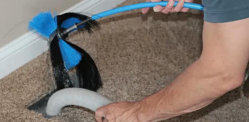 Dryer vent cleaning technician brushing lint from a vent line in Eugene, OR