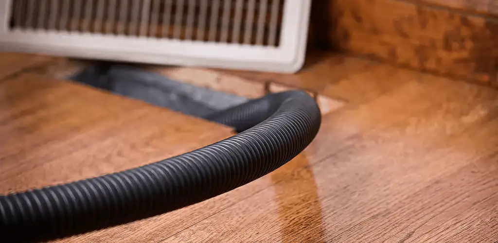 Air duct cleaning hose inserted into a floor vent for ductwork cleaning in Eugene, OR